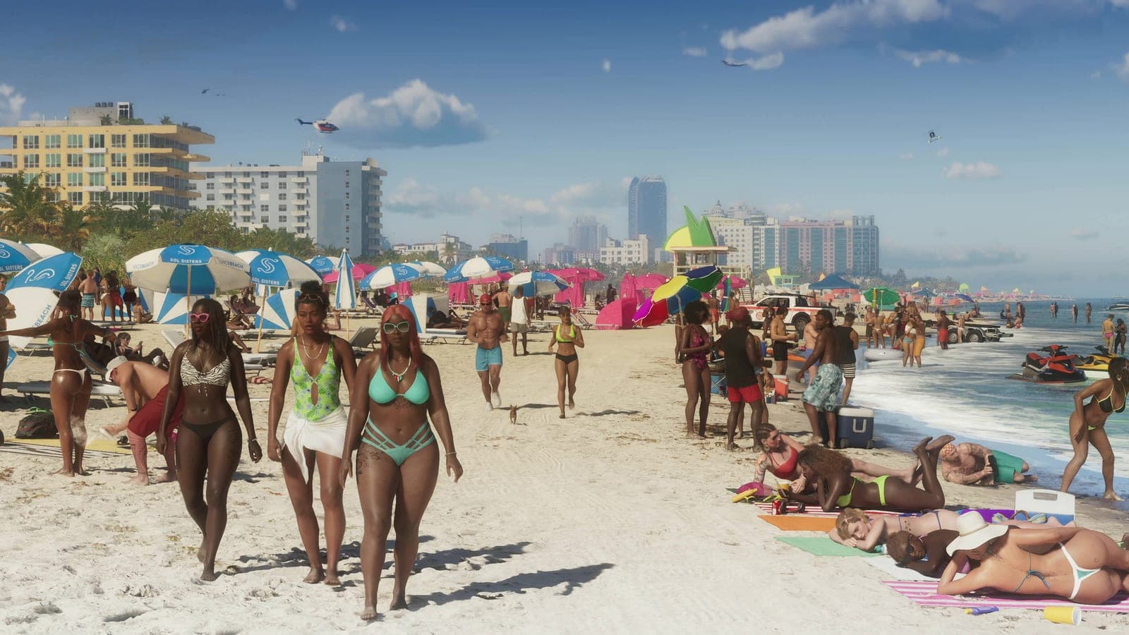A crowded beach in bright sun, dozens of people on the sand and in the surf, rows of parasols, jet skis offshore and a line of towers along the far shore.